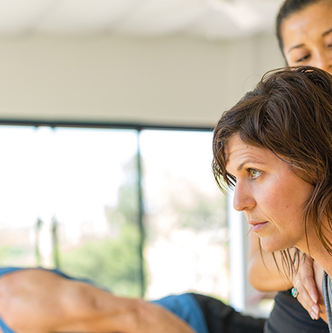 An instructor adjusting a student's shoulders during class