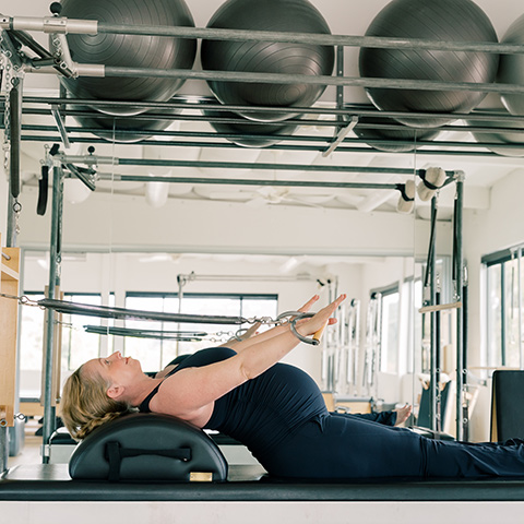 Pregnant woman performs Pilates